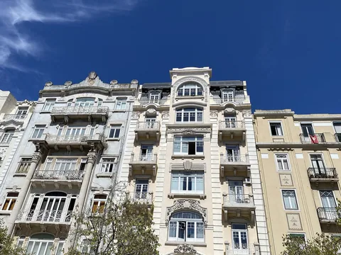 Fasader på flerfamiljshus vid Avenida Duque d'Ávila i Lissabon mot blå himmel