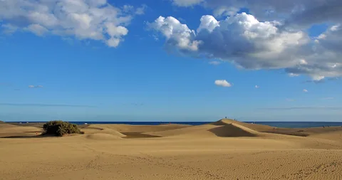 Sanddyner vid Maspalomas på Gran Canaria under blå himmel med stapelmoln