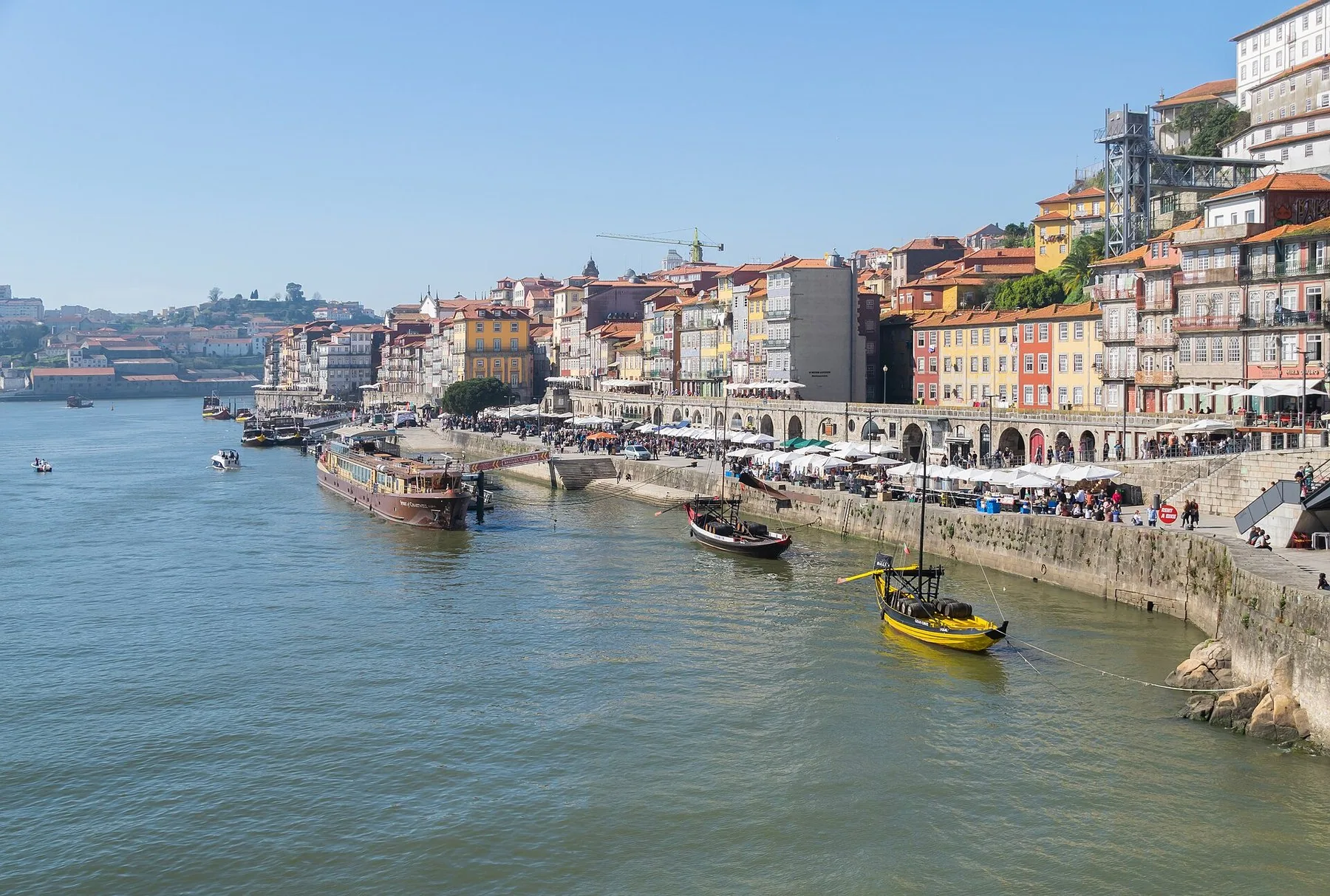 Ribeirakajen i Porto med färgglada husfasader och rabelobåtar vid Dourofloden