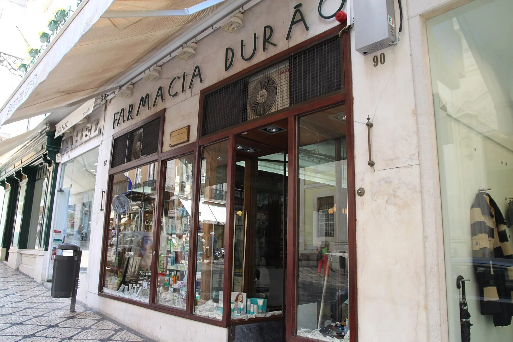 Apoteksfasad med namnet Farmácia Durão över skyltfönstren vid en gata i Lissabon