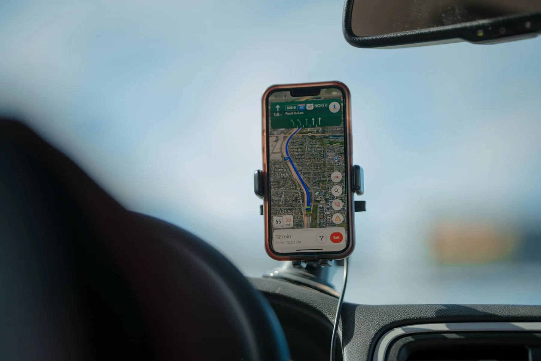 Mobiltelefon i hållare på en instrumentbräda som visar en navigationskarta