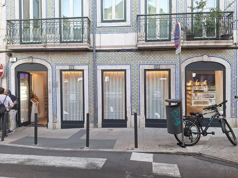 Apotek med skylten Farmácia Almeida i en husfasad klädd med blå och gula azulejos