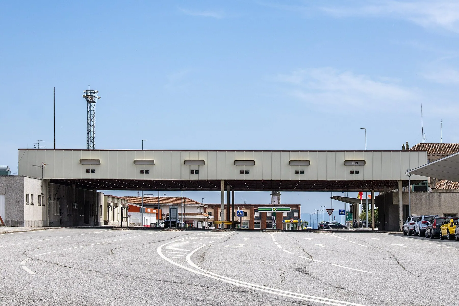 Tom gränsstation med skärmtak och kontrollbås vid en avstängd väg