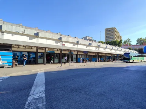 Bussterminalen i Sete Rios i Lissabon med en lång rad avgångsportar under ett betongskärmtak och en långfärdsbuss vid perrongen längst bort