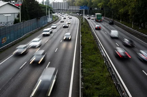 Tät trafik i båda riktningarna på en portugisisk motorväg med mittbarriär, sedd uppifrån en bro
